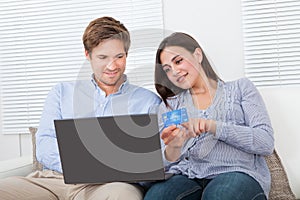 Couple Using Laptop And Credit Card To Shop Online