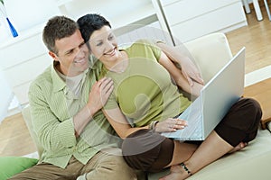 Couple using laptop at home