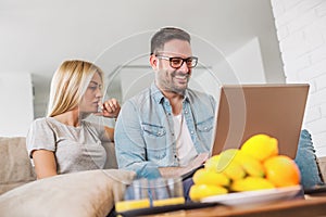 Couple using laptop in their living room