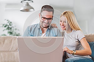 Couple using laptop in their living room