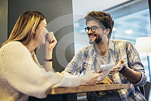 Couple using mobile phone in a cafe