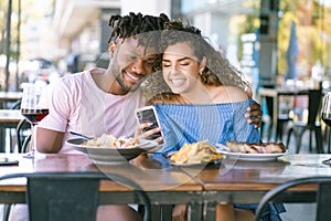 Couple using a mobile phone at a restaurant.
