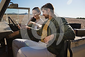 Couple using phone in off road vehicle