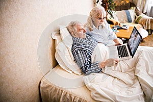 Couple using portable computer in bed