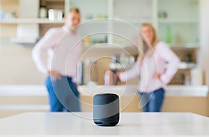Couple using smart speaker at home photo