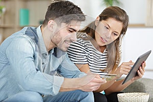couple using tablet and credit card for online shopping
