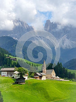 couple on vacation in the Italian Dolomites,Santa Magdalena village with magical Dolomites mountains in autumn, Val di