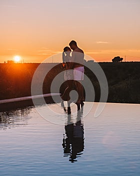 Couple on vacation at luxury resort in Sicily during sunset by the infinity pool in Sicilia Italy
