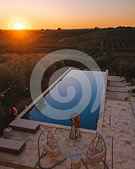 Couple on vacation at luxury resort in Sicily during sunset by the infinity pool in Sicilia Italy