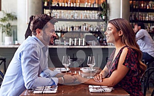 Couple On Valentines Day First Date Sitting At Table In Restaurant photo