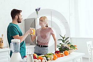 couple of vegans clinking with glasses of orange juice