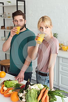 couple of vegans drinking fresh juice at kitchen