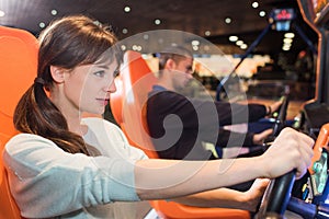 Couple in video game arcade playing driving games