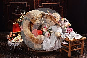 A couple of vintage style teddy bears sitting on sofa and celebrating Valentines Day