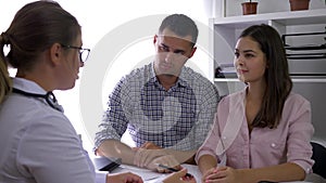 Couple visiting doctor at fertility clinic, husband and wife on physician consultation in a medical room