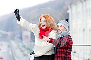 Couple wag to air. Red hair woman wag from the bridge. Happy lady with guy welcomes to friends. photo