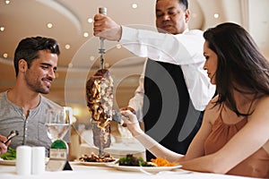 Couple, waiter and service for lunch in restaurant with meat, happiness and fine dining for anniversary or honeymoon