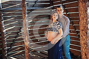 Couple waiting for baby photo shoot in a wooden house