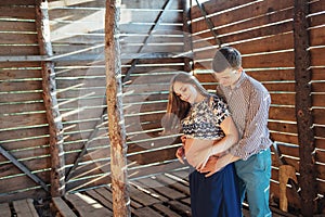 Couple waiting for baby photo shoot in a wooden house