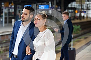 Couple waiting on platform at train station