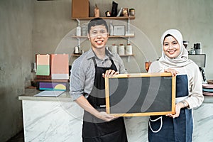 Couple waitress standing hold a blackboard