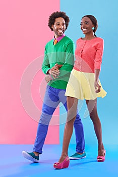 Couple, walk and happy with fashion in studio, background and creative aesthetic. Excited, woman and man together with