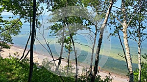 Couple walk on sandy baltic sea beach on vacation with clear calm coast waters. Panorama from Dutchman\'s cap viewpoint.