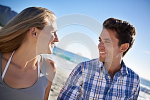 Couple, walk and smile on beach, talk and outdoor in summer sunshine for vacation, thinking or travel. Man, woman and