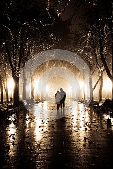 Couple walking at alley in night lights.