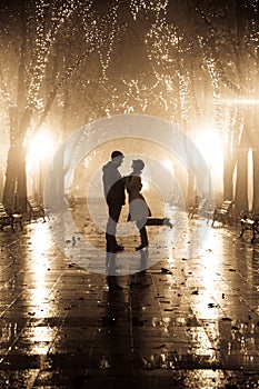 Couple walking at alley in night lights.