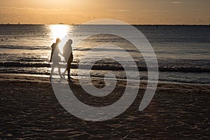 Couple Walking Along the Beach at Sunrise