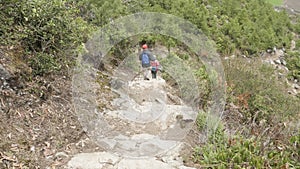 Couple walking along the stairs on the trek around Manaslu, village Prok, Nepal.