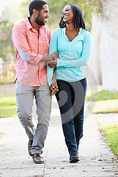 Couple Walking Along Suburban Street Together