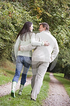 Couple walking along woodland path