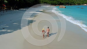 Couple walking on the beach of Anse Lazio beach Praslin island Seychelles