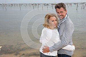 Couple walking on beach arm in arm smiling