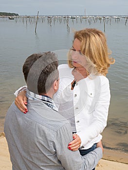 Couple walking on beach, happy middle aged couple walking