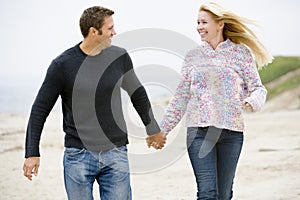 Couple walking at beach holding hands