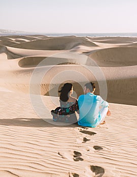 couple walking at the beach of Maspalomas Gran Canaria Spain, men and woman at the sand dunes desert