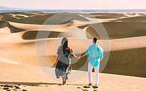 couple walking at the beach of Maspalomas Gran Canaria Spain, men and woman at the sand dunes desert