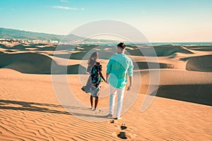 couple walking at the beach of Maspalomas Gran Canaria Spain, men and woman at the sand dunes desert of Maspalomas