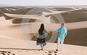 couple walking at the beach of Maspalomas Gran Canaria Spain, men and woman at the sand dunes desert