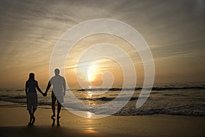 Couple Walking on Beach at Sunset