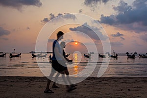 Couple walking on the beach at sunset