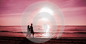 Couple walking on beach.