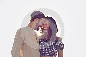 Couple walking on beach. Young happy interracial couple walking on beach smiling holding around each other.