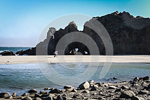 Couple walking on the beautiful and mountainous Big Sur Coast of California, United States of America aka USA