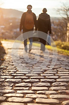 Couple walking on cobblestone foot path