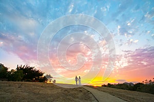 Couple walking into a colorful sunset