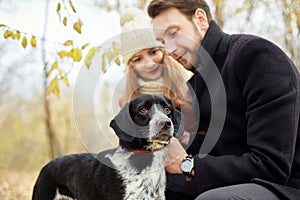 Couple walking with dog in the Park and hugging. Autumn walk men